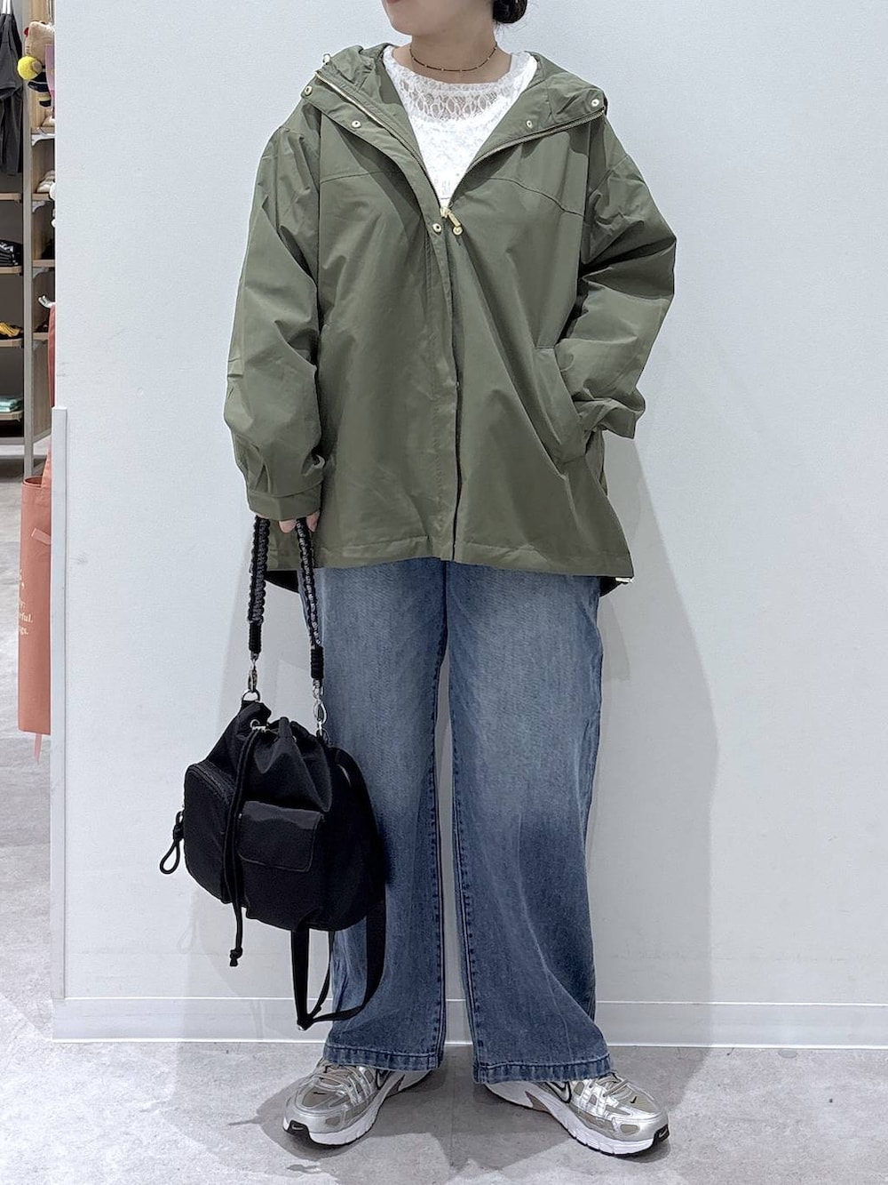 ブルー系のデニムパンツ、ホワイト系のTシャツ/カットソー、グリーン系のマウンテンパーカーを着用したレディースの秋コーディネートの5枚目の写真