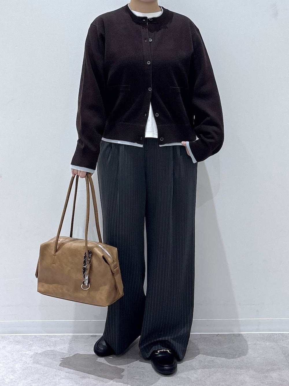 グレー系のその他パンツ、ブラック系のローファー、ホワイト系のTシャツ/カットソーを着用したレディースの秋コーディネートの4枚目の写真