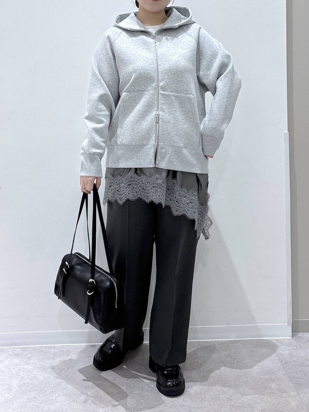 グレー系のパーカー、グレー系のその他パンツ、ブラック系のショルダーバッグを着用したレディースの春コーディネートの4枚目の写真
