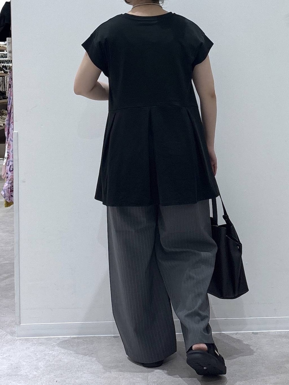 ブラック系のハンドバッグ、グレー系のその他パンツ、ブラック系のTシャツ/カットソーを着用したレディースの夏コーディネートの3枚目の写真