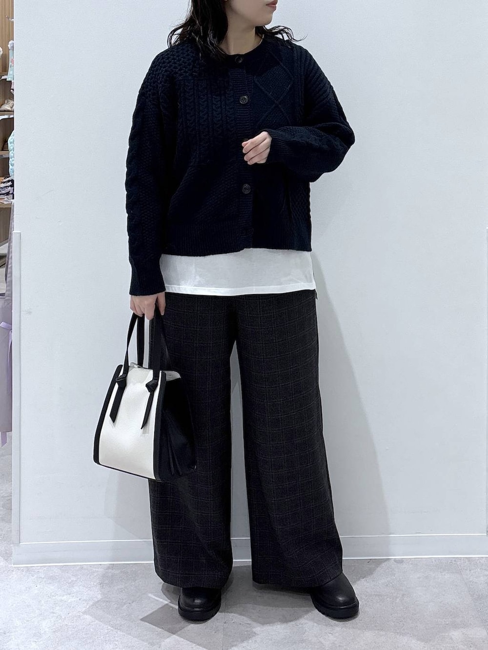 ホワイト系のショルダーバッグ、ホワイト系のTシャツ/カットソー、ブラック系のブーツを着用したレディースの秋コーディネートの5枚目の写真