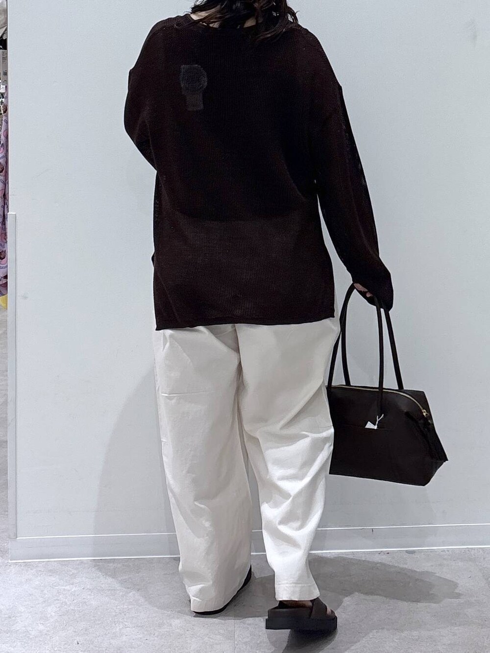 ブラウン系のボストンバッグ、ベージュ系のその他パンツ、ブラウン系のニット/セーターを着用したレディースの夏コーディネートの3枚目の写真