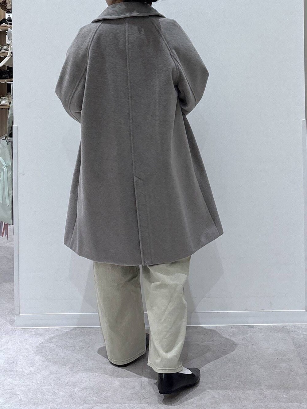 ブラック系のパンプス、ベージュ系のデニムパンツ、ベージュ系のチェスターコートを着用したレディースの冬コーディネートの3枚目の写真