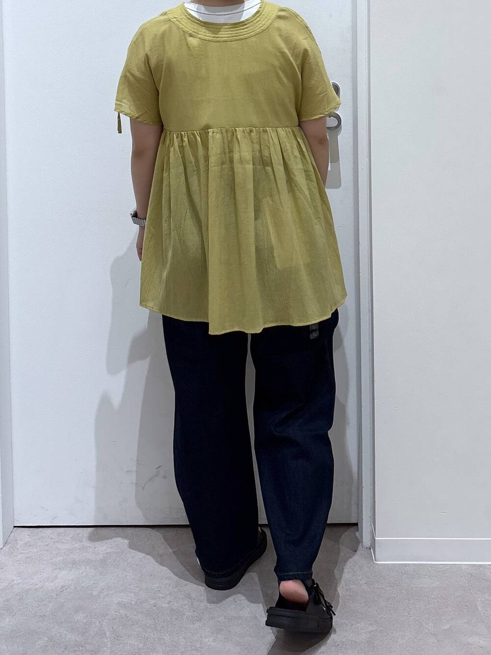 ブルー系のデニムパンツ、イエロー系のシャツ/ブラウス、ブラック系のサンダルを着用したレディースの夏コーディネートの3枚目の写真