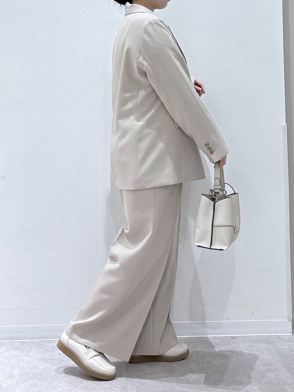 ホワイト系のローファー、ホワイト系のシャツ/ブラウス、ベージュ系のショルダーバッグを着用したレディースの冬コーディネートの2枚目の写真