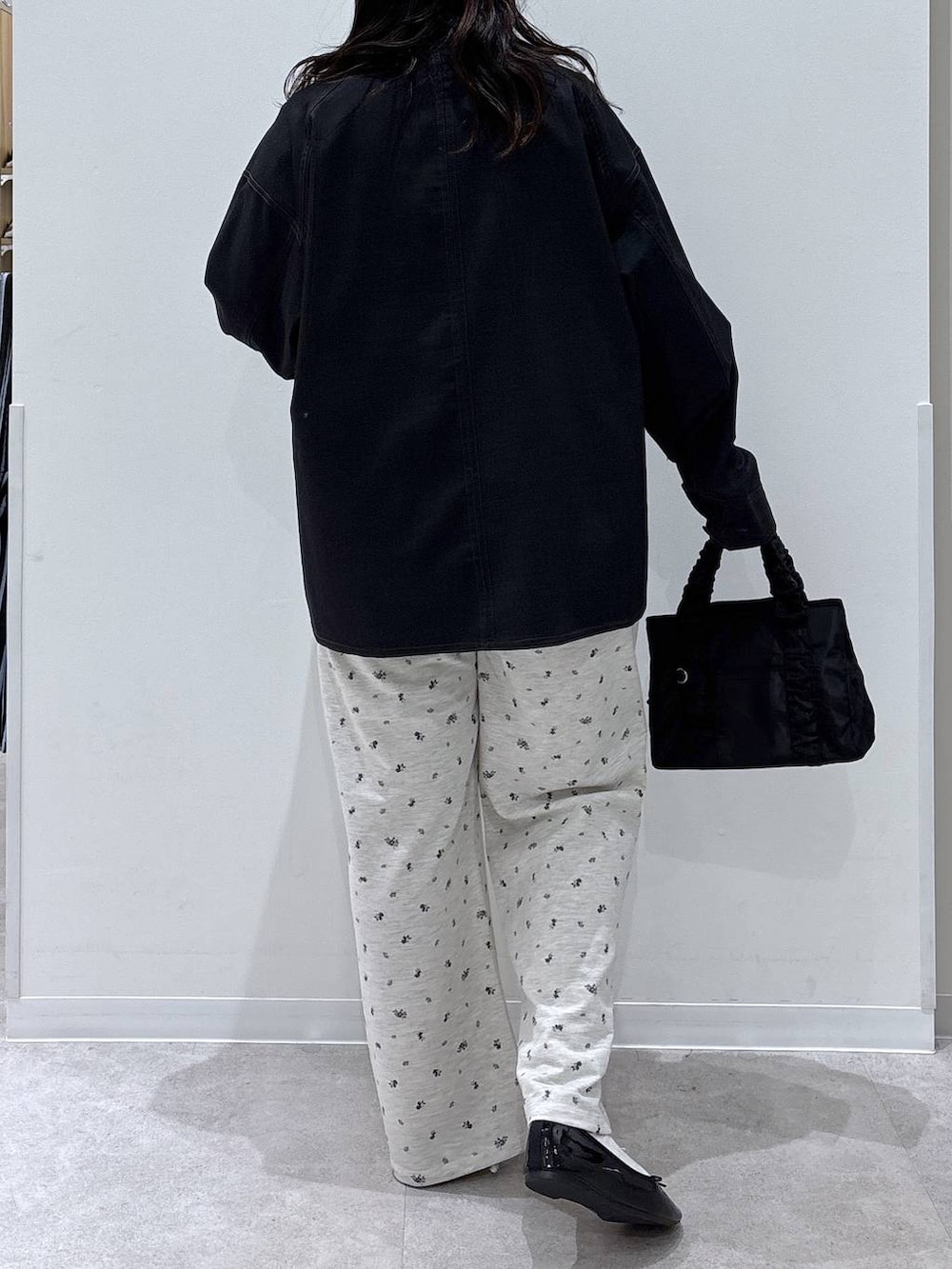 ブラック系のバレエシューズ、ブラック系のショルダーバッグ、ブルー系のブルゾンを着用したレディースの春コーディネートの3枚目の写真