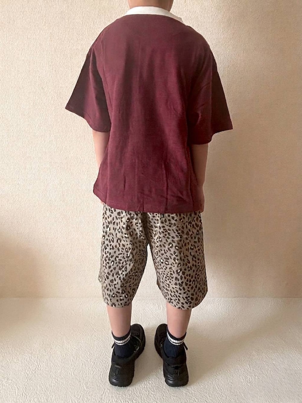 ブラウン系のその他パンツ、ブラック系のスニーカー、レッド系のTシャツ/カットソーを着用したキッズの春コーディネートの2枚目の写真