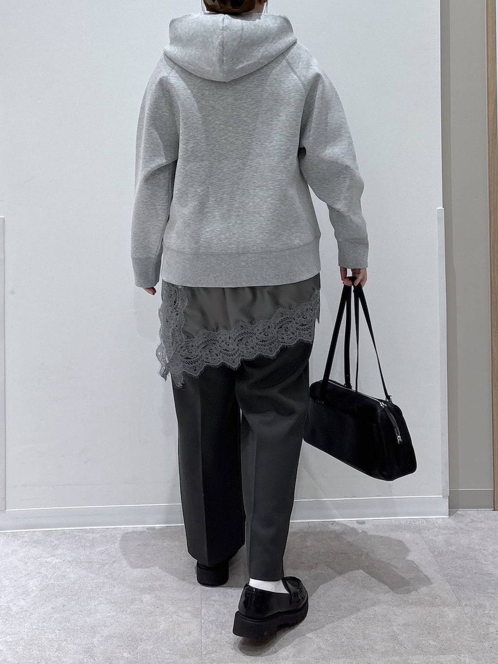 グレー系のパーカー、グレー系のその他パンツ、ブラック系のショルダーバッグを着用したレディースの春コーディネートの3枚目の写真