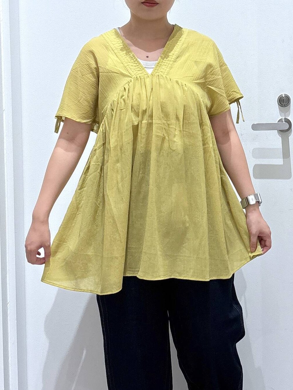 ブルー系のデニムパンツ、イエロー系のシャツ/ブラウス、ブラック系のサンダルを着用したレディースの夏コーディネートの4枚目の写真