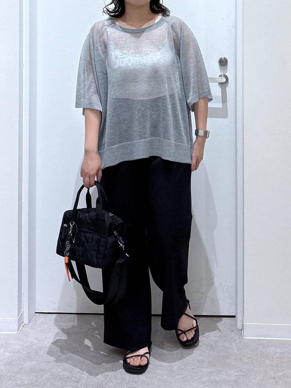 グレー系のニット/セーター、ブラック系のその他パンツ、ブラック系のボストンバッグを着用したレディースの夏コーディネートの3枚目の写真