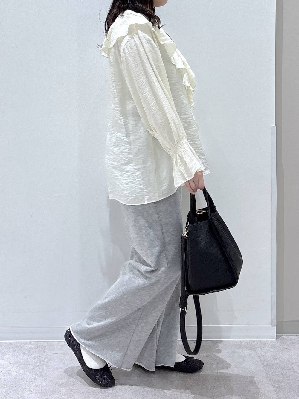 ブラック系のバレエシューズ、ブラック系のトートバッグ、グレー系のスウェットパンツを着用したレディースの春コーディネートの2枚目の写真