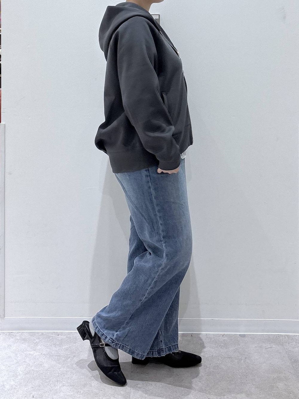 グレー系のパーカー、ブルー系のデニムパンツ、ホワイト系のTシャツ/カットソーを着用したレディースの秋コーディネートの2枚目の写真