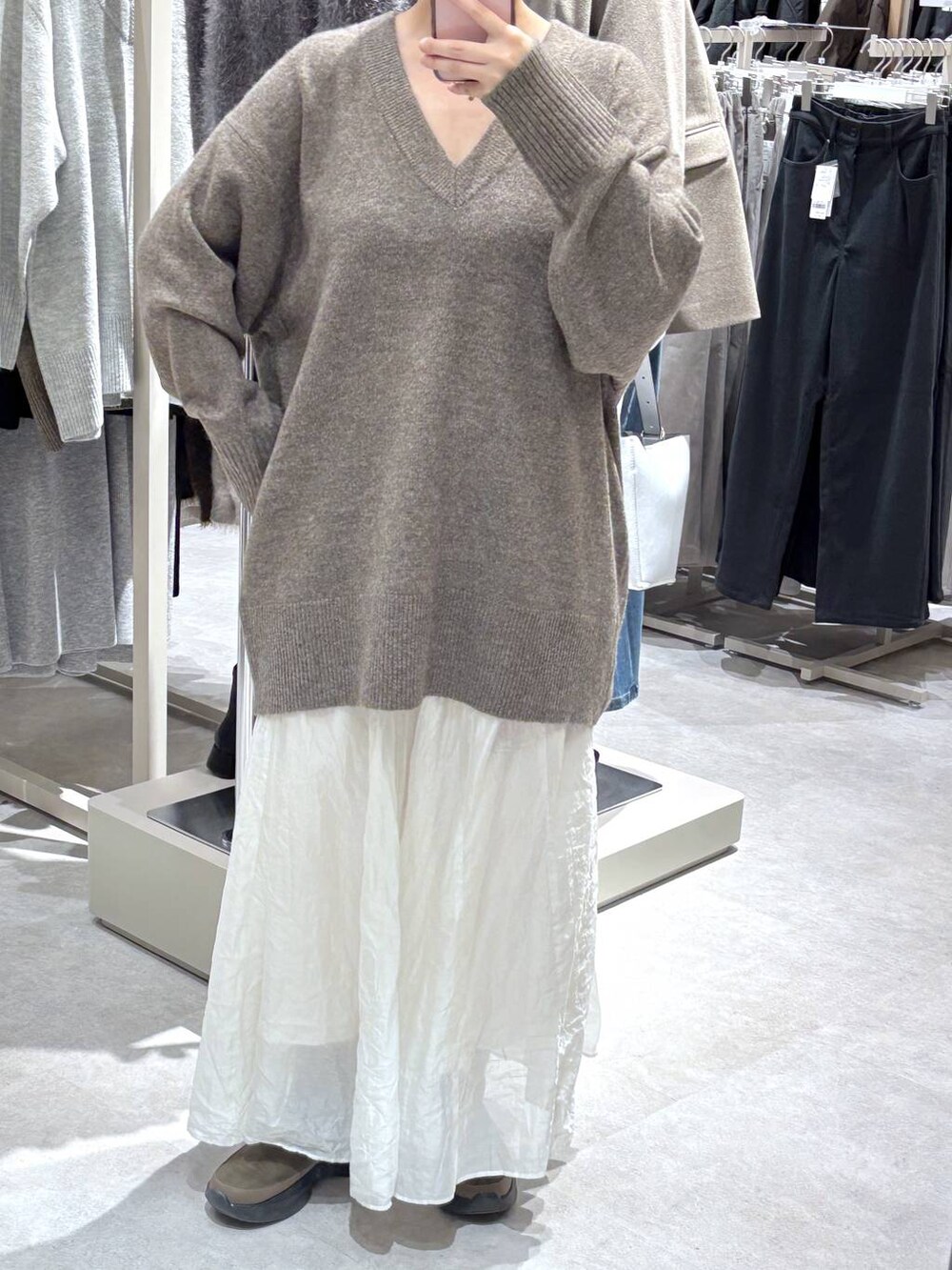 ベージュ系のスカート、ブラウン系のブーツを着用したレディースの秋コーディネートの2枚目の写真