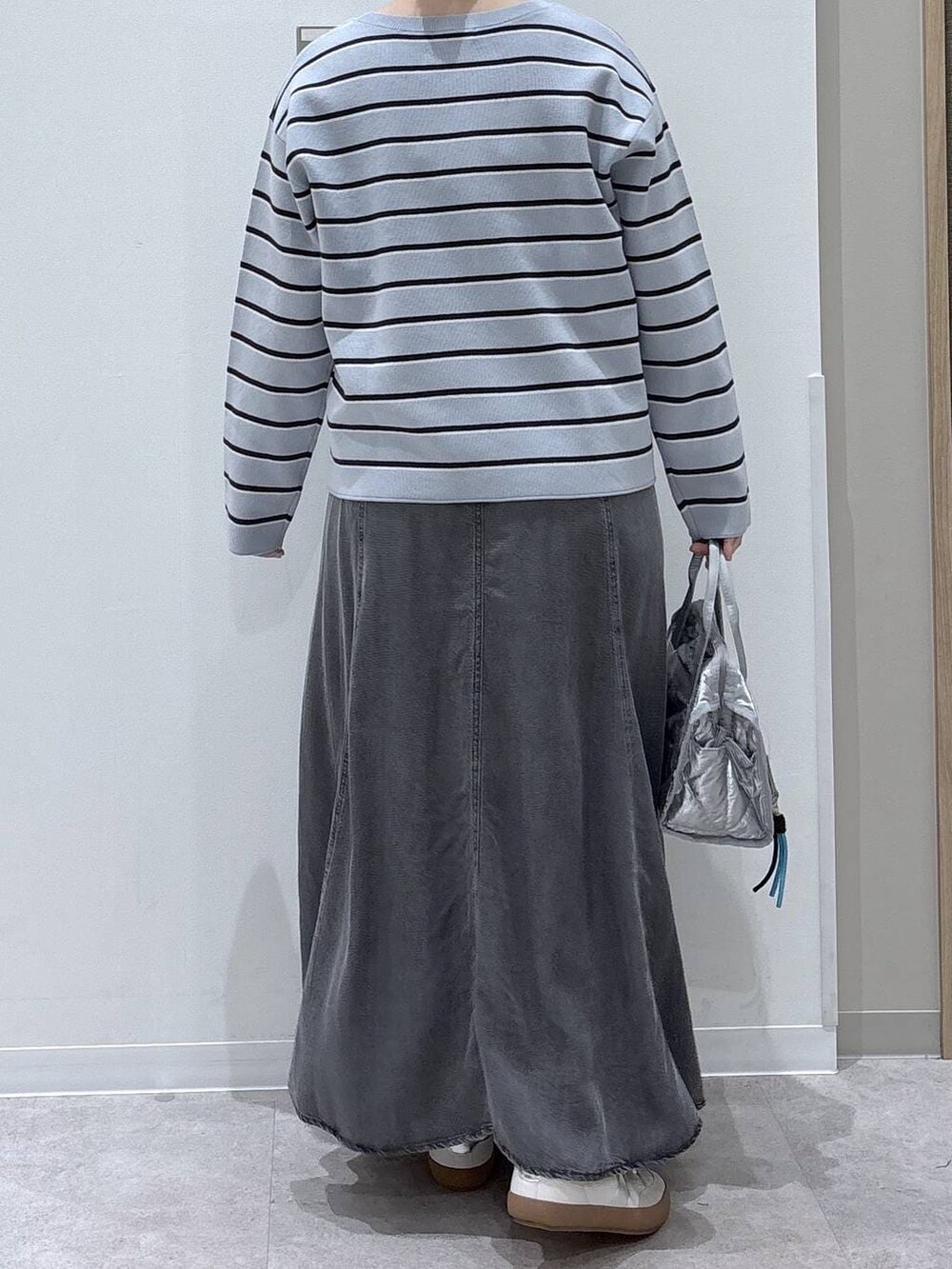 ホワイト系のスニーカー、シルバー系のボストンバッグ、ブルー系のニット/セーターを着用したレディースの春コーディネートの3枚目の写真