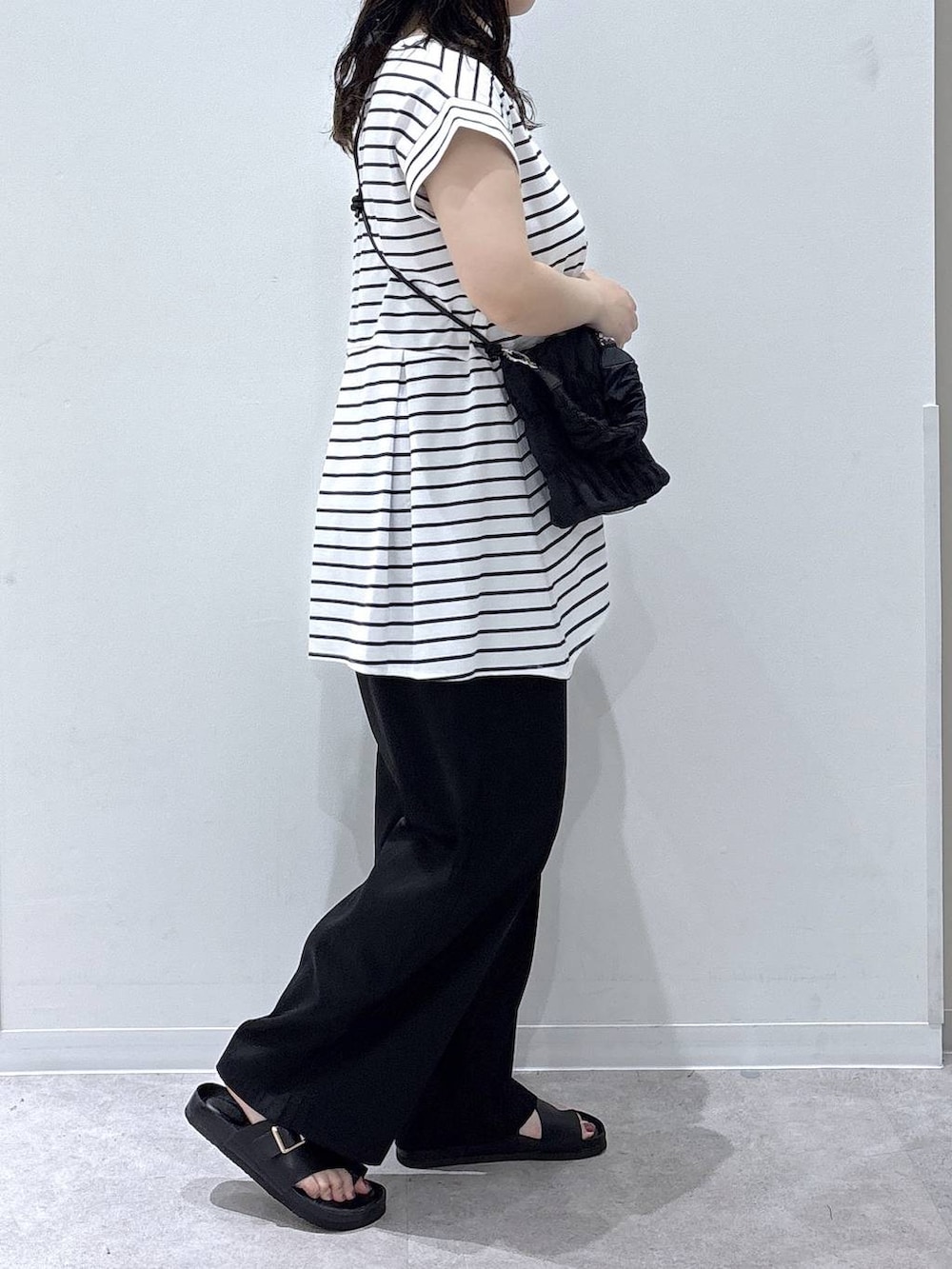 ホワイト系のTシャツ/カットソー、ブラック系のその他パンツ、ブラック系のサンダルを着用したレディースの夏コーディネートの2枚目の写真