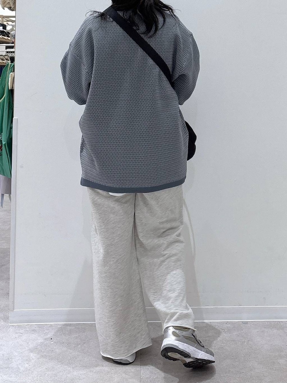 ブラック系のショルダーバッグ、ホワイト系のスウェットパンツ、ブルー系のニット/セーターを着用したレディースの冬コーディネートの3枚目の写真