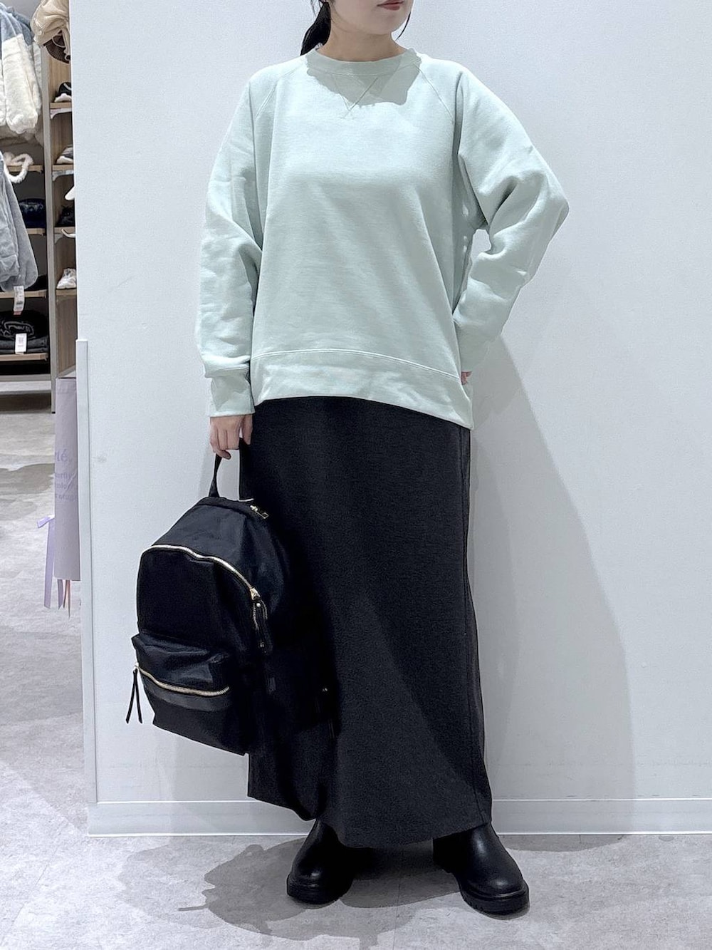 ブラック系のバックパック/リュック、ブラック系のブーツ、グレー系のスカートを着用したレディースの冬コーディネートの4枚目の写真