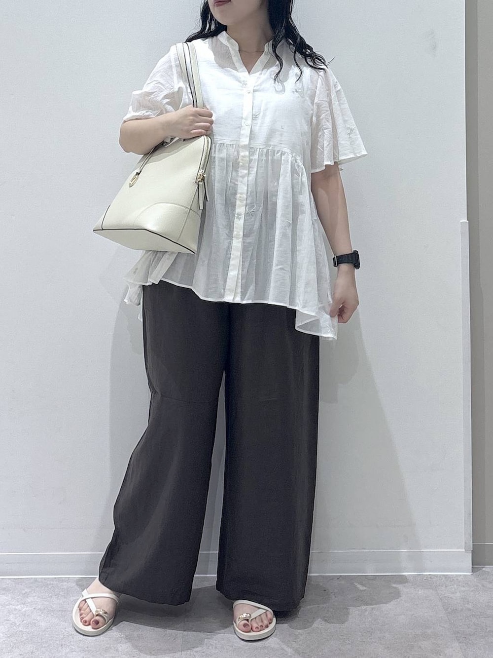 ブラウン系のその他パンツ、ベージュ系のボストンバッグ、ホワイト系のサンダルを着用したレディースの夏コーディネートの4枚目の写真