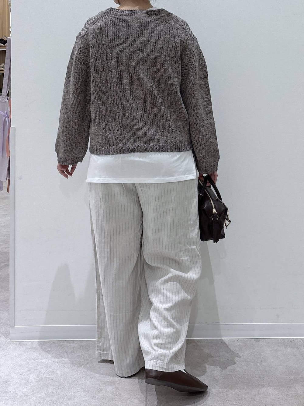 ブラウン系のボストンバッグ、ベージュ系のその他パンツ、ベージュ系のニット/セーターを着用したレディースの春コーディネートの3枚目の写真