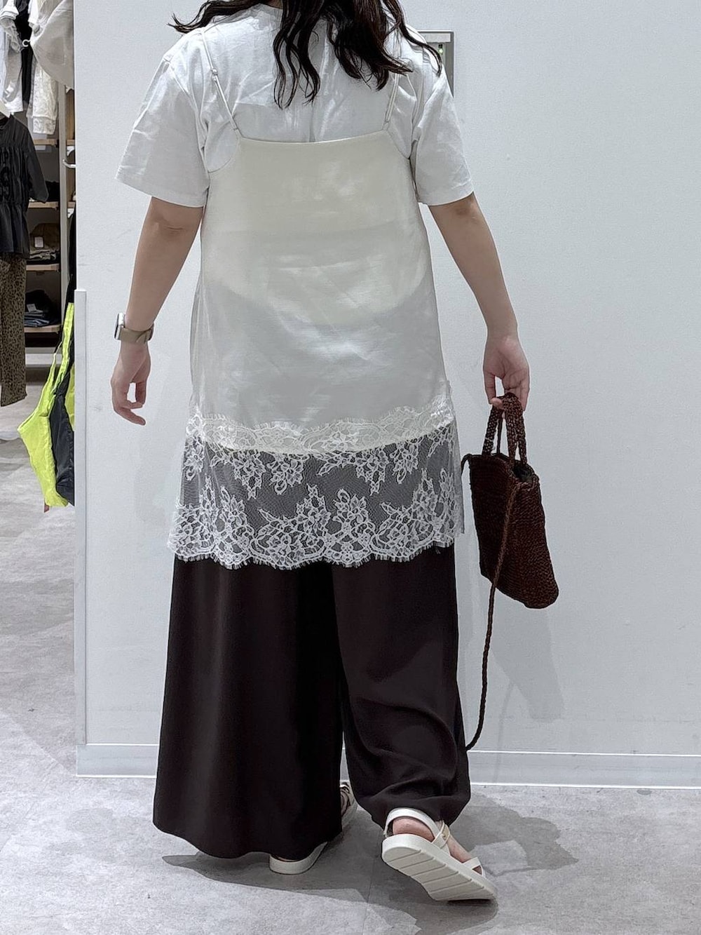 ブラウン系のその他パンツ、ホワイト系のTシャツ/カットソー、ブラウン系のクラッチバッグを着用したレディースの夏コーディネートの3枚目の写真
