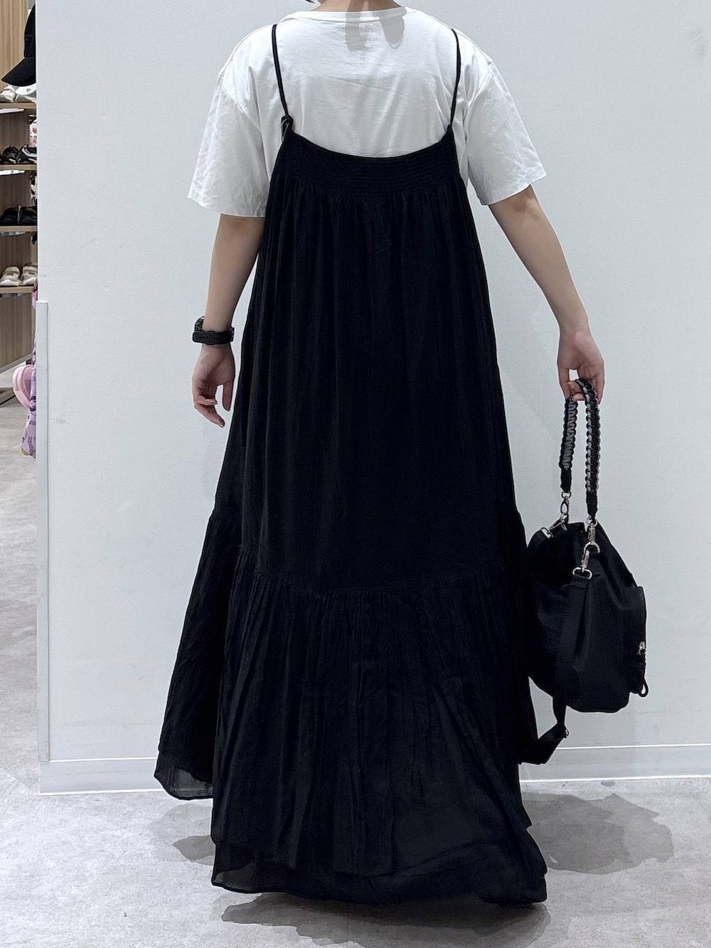 ブラック系のワンピース、ホワイト系のTシャツ/カットソー、ブラック系のサンダルを着用したレディースの夏コーディネートの3枚目の写真