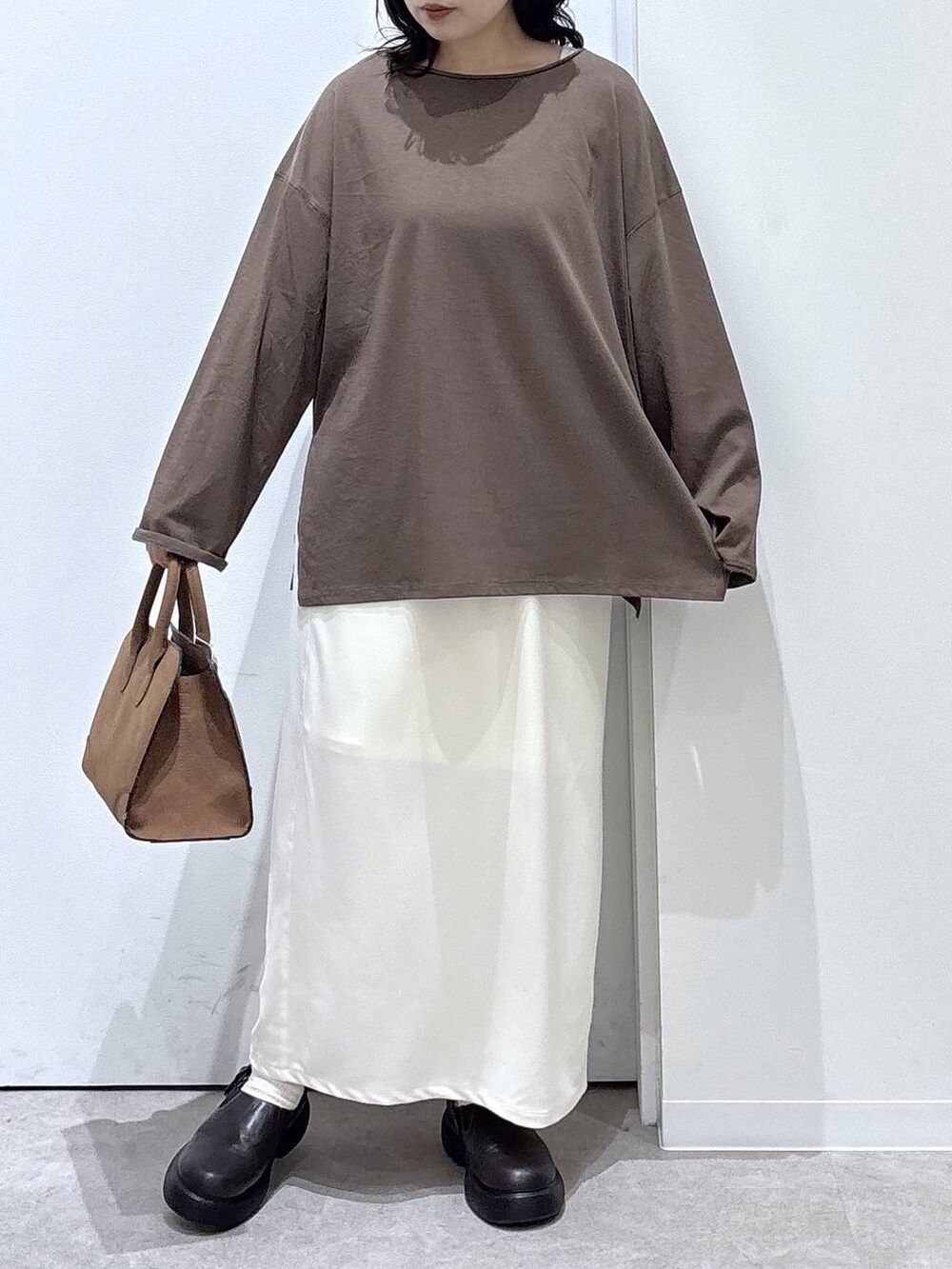ベージュ系のショルダーバッグ、ベージュ系のスカート、ブラウン系のTシャツ/カットソーを着用したレディースの秋コーディネートの4枚目の写真