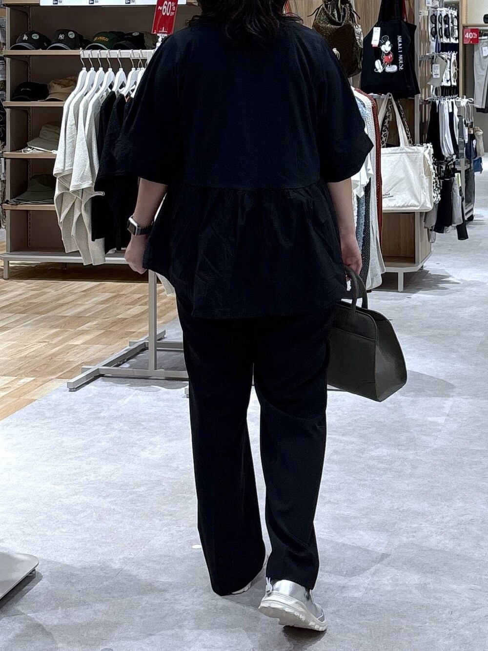 グレー系のスニーカー、ブラック系のスラックス、グリーン系のショルダーバッグを着用したレディースの秋コーディネートの3枚目の写真