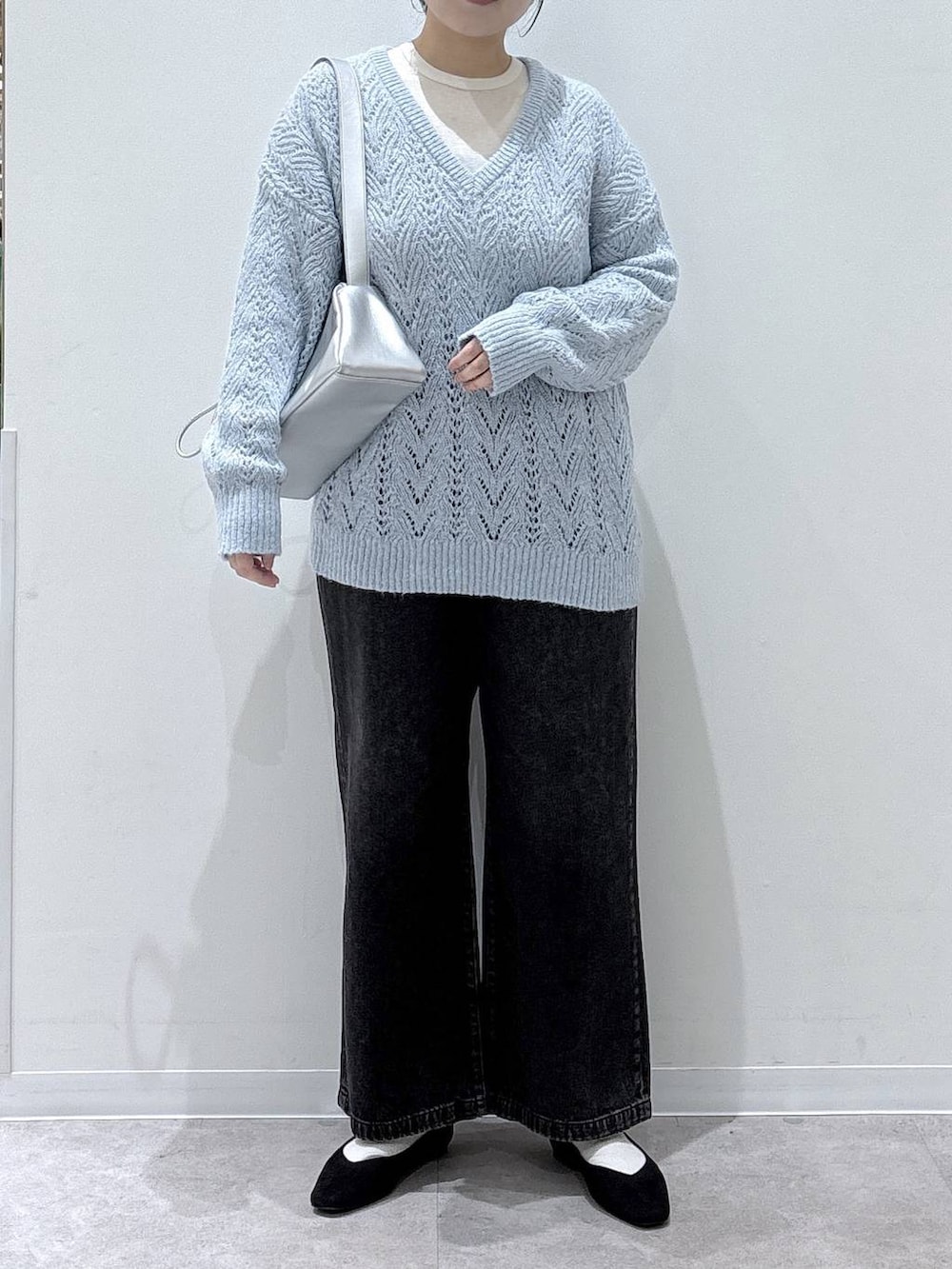 ブラック系のパンプス、ブラック系のデニムパンツ、ブルー系のニット/セーターを着用したレディースの冬コーディネートの3枚目の写真