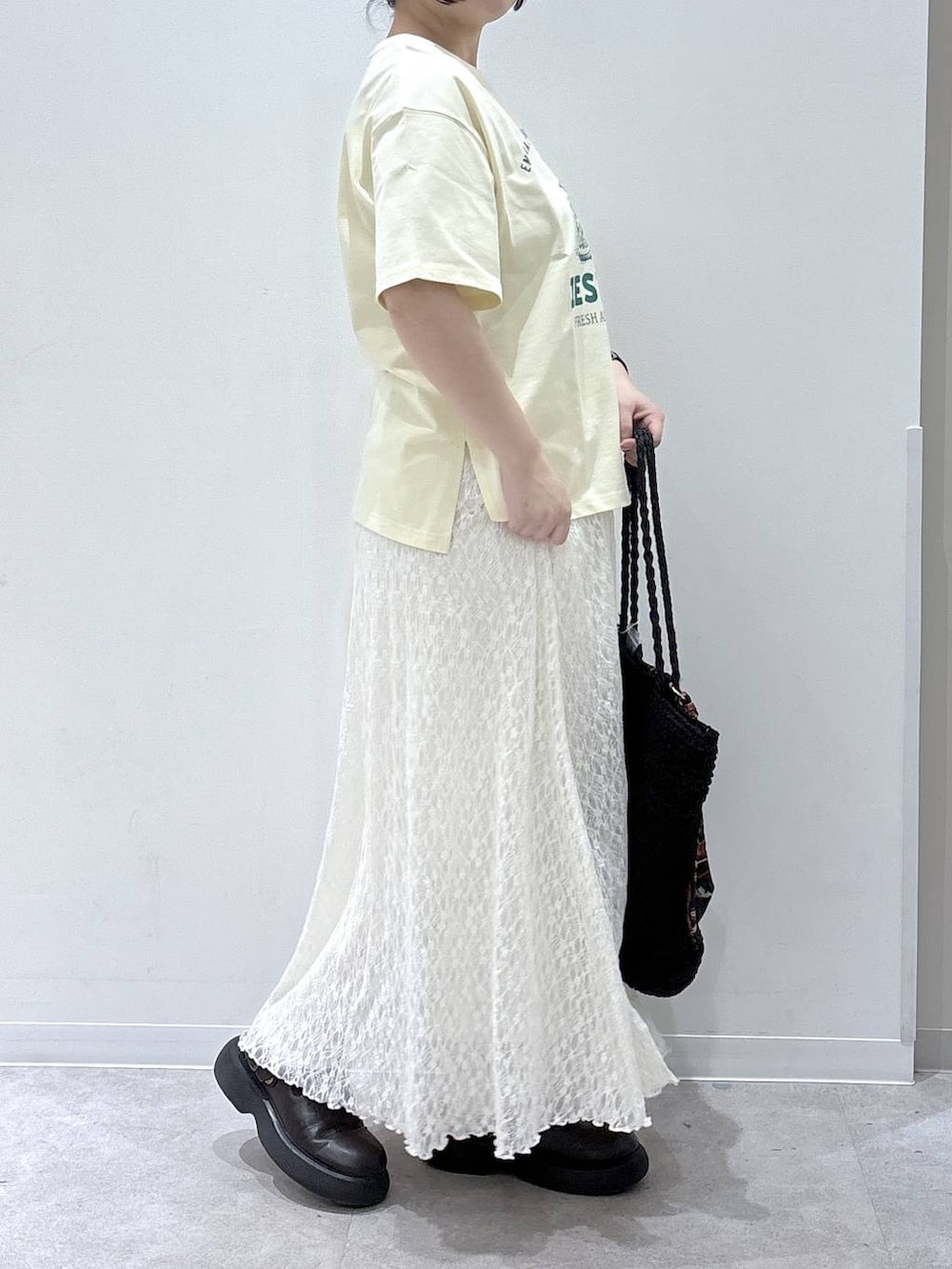 イエロー系のTシャツ/カットソー、ホワイト系のスカートを着用したレディースの春コーディネートの2枚目の写真