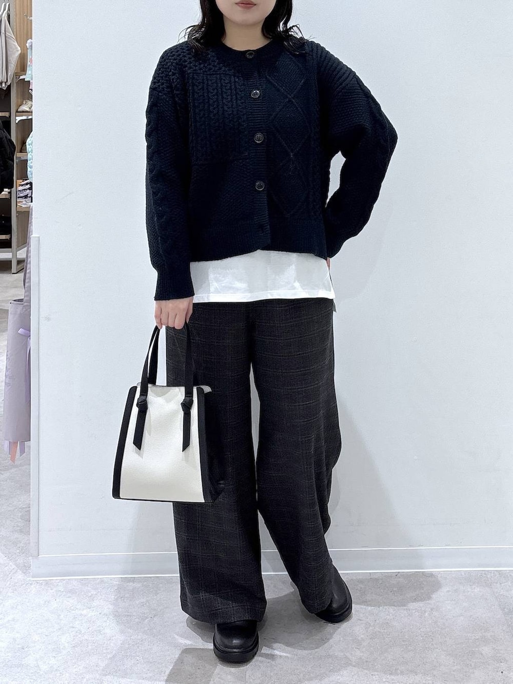 ホワイト系のショルダーバッグ、ホワイト系のTシャツ/カットソー、ブラック系のブーツを着用したレディースの秋コーディネートの4枚目の写真