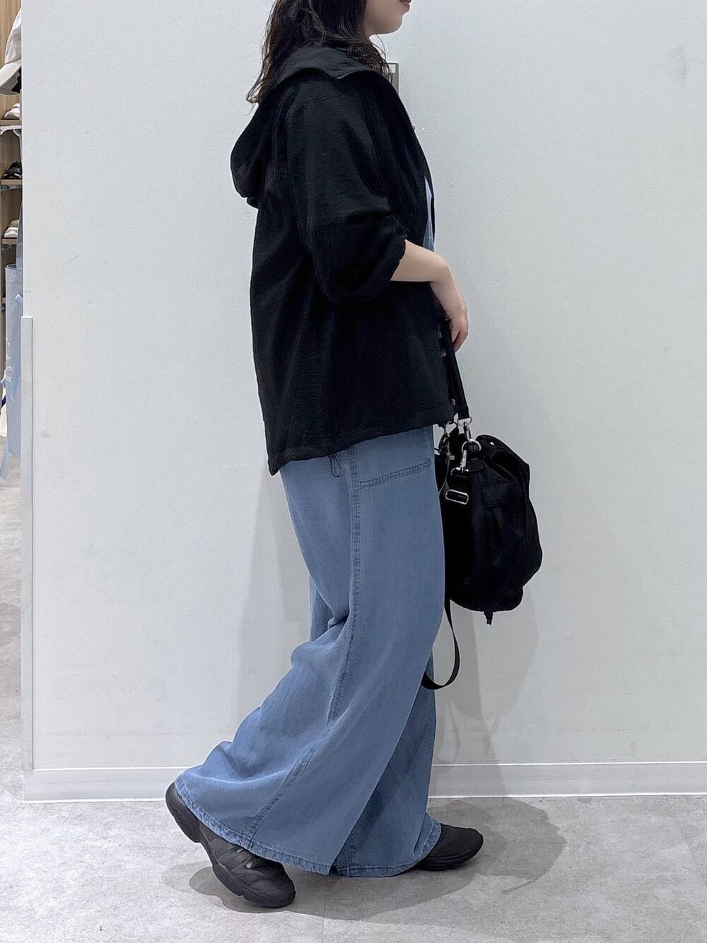 ブラック系のショルダーバッグ、ブラック系のマウンテンパーカー、グレー系のTシャツ/カットソーを着用したレディースの春コーディネートの2枚目の写真