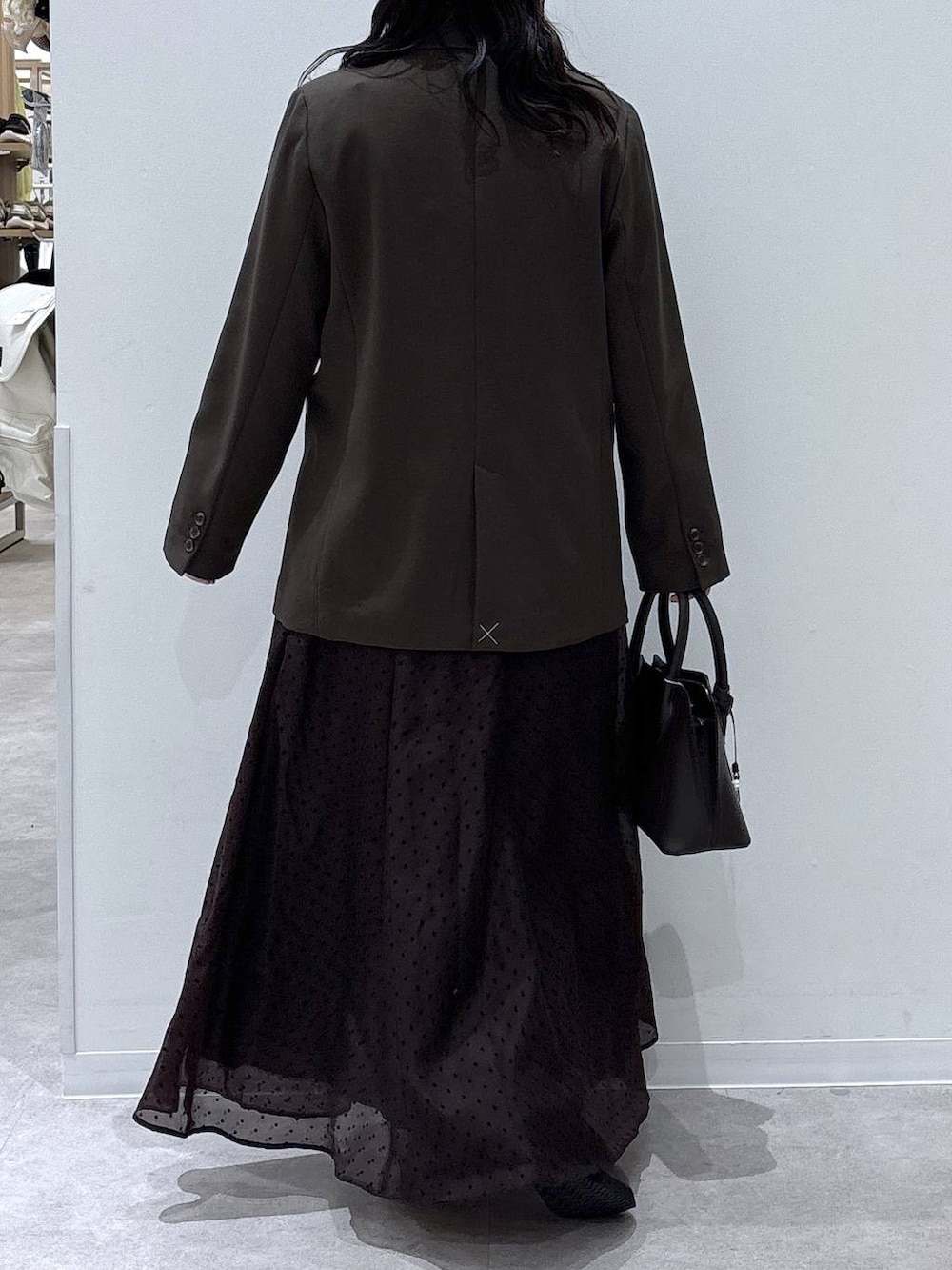 ブラウン系のショルダーバッグ、ブラウン系のテーラードジャケット、ブラウン系のスカートを着用したレディースの冬コーディネートの3枚目の写真