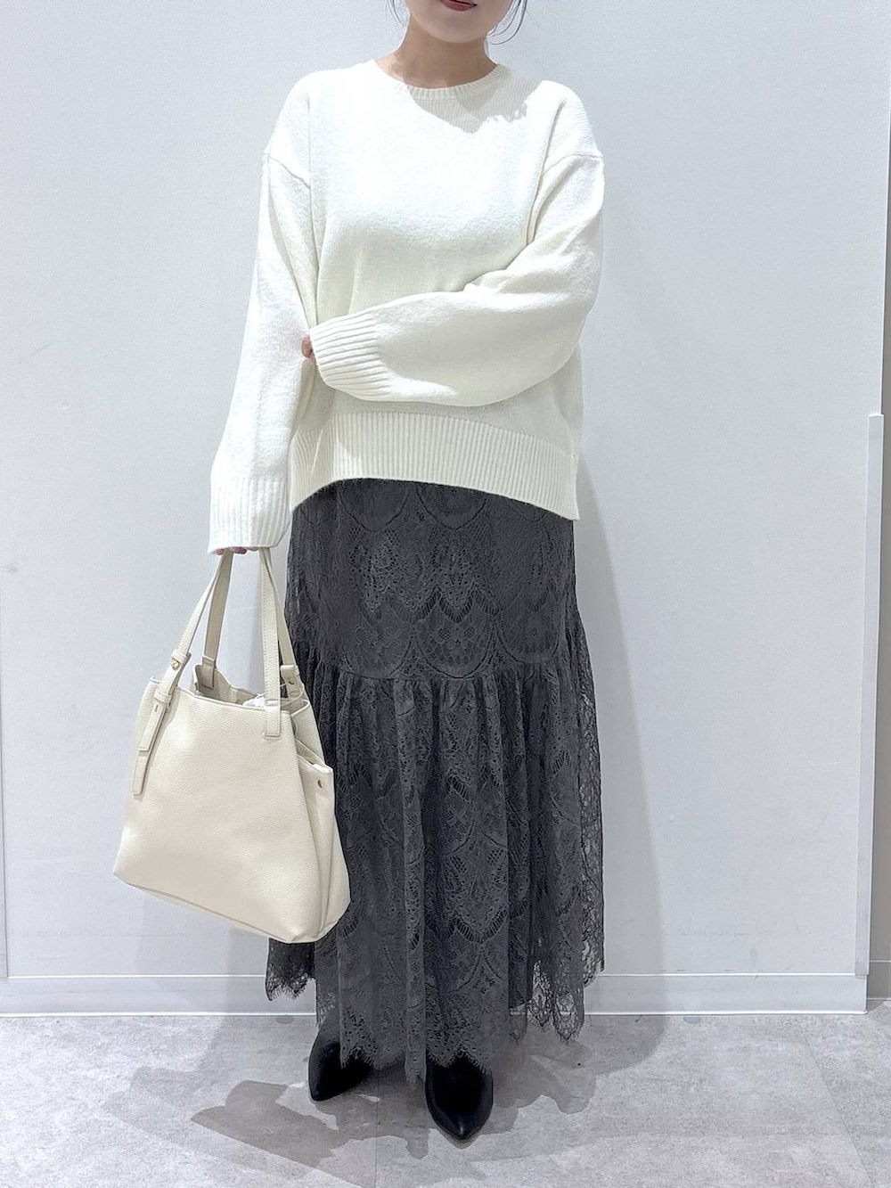 ホワイト系のショルダーバッグ、グレー系のブルゾン、グレー系のワンピースを着用したレディースの冬コーディネートの4枚目の写真