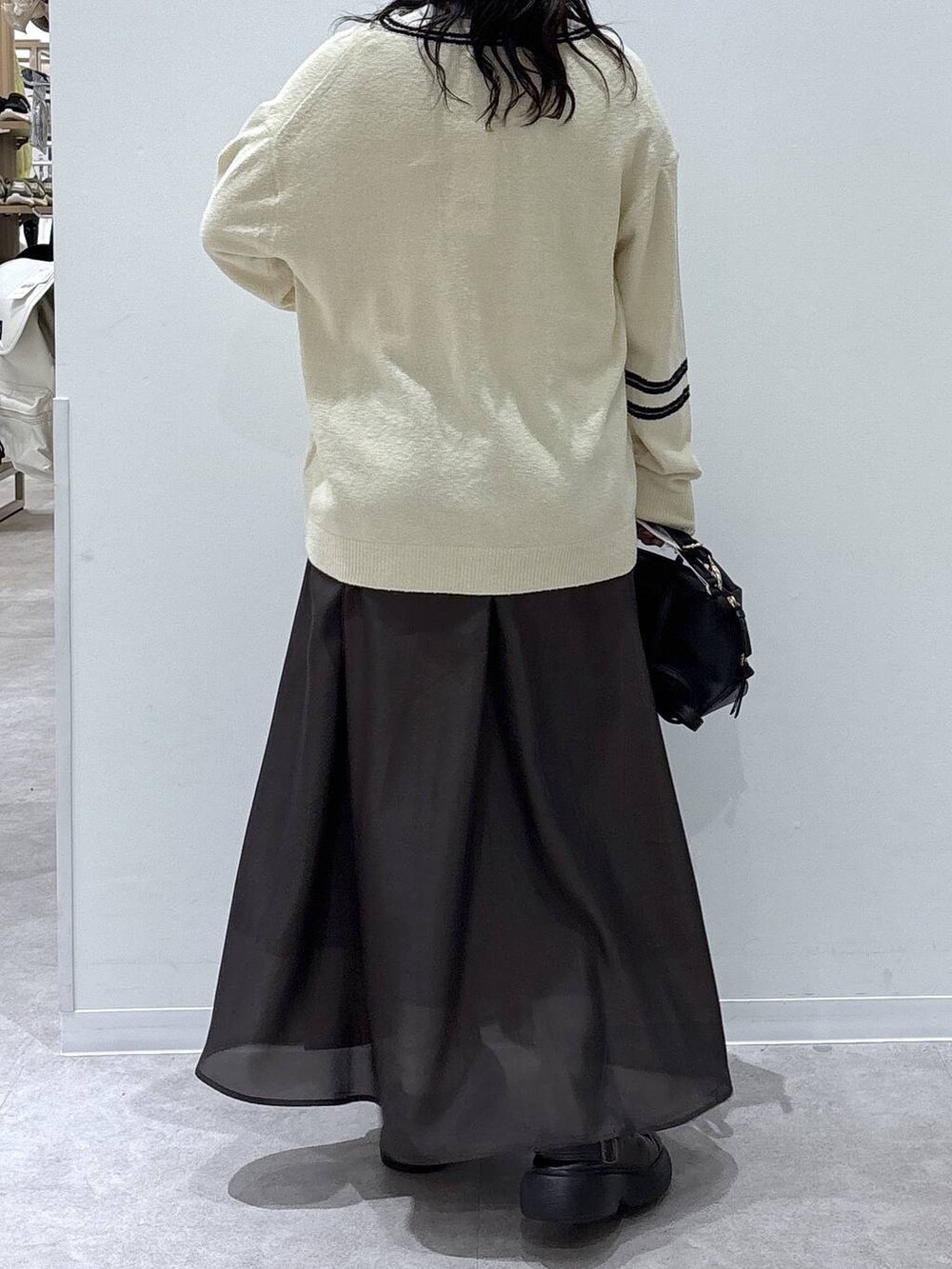 ブラック系のショルダーバッグ、ブラウン系のスカートを着用したレディースの冬コーディネートの3枚目の写真