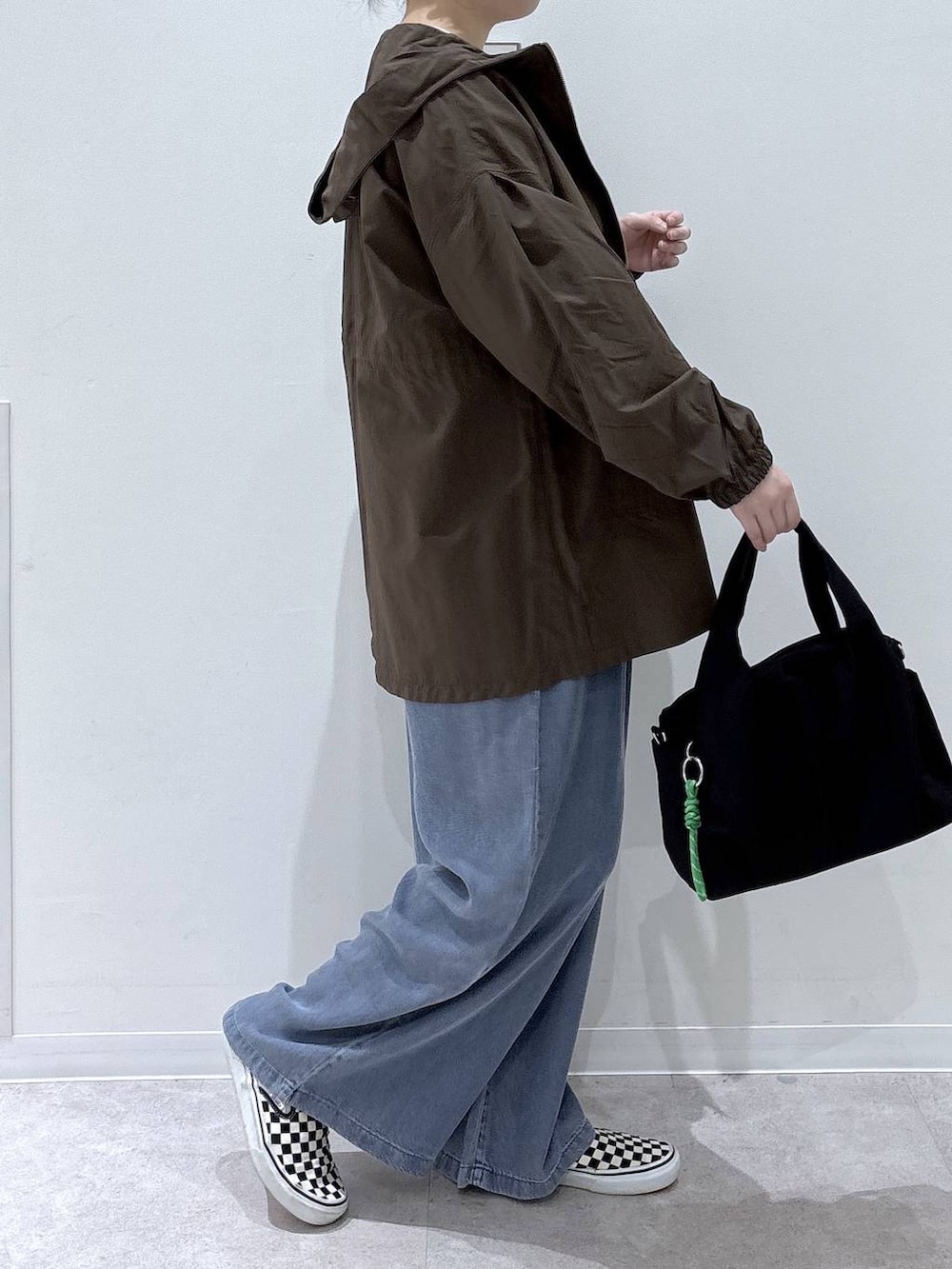 ブラック系のトートバッグ、グリーン系のマウンテンパーカー、ピンク系のニット/セーターを着用したレディースの春コーディネートの2枚目の写真