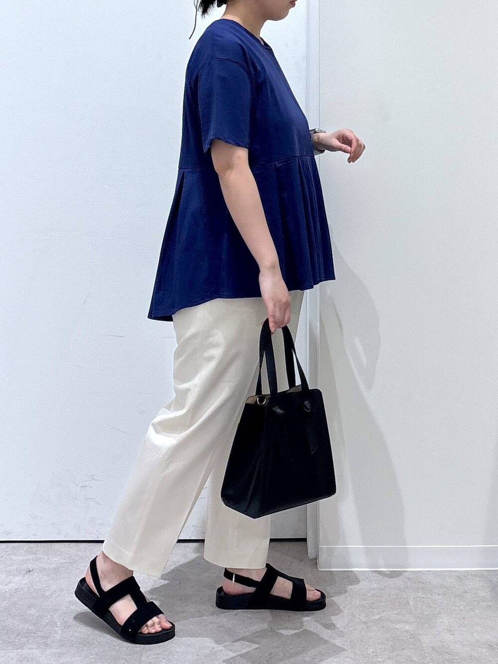 ホワイト系のその他パンツ、ブラック系のショルダーバッグ、ブルー系のTシャツ/カットソーを着用したレディースの春コーディネートの2枚目の写真