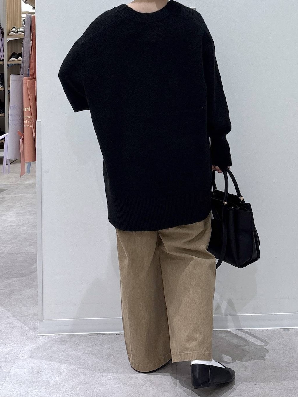 ブラック系のその他シューズ、ブラック系のトートバッグ、ブラック系のニット/セーターを着用したレディースの冬コーディネートの3枚目の写真