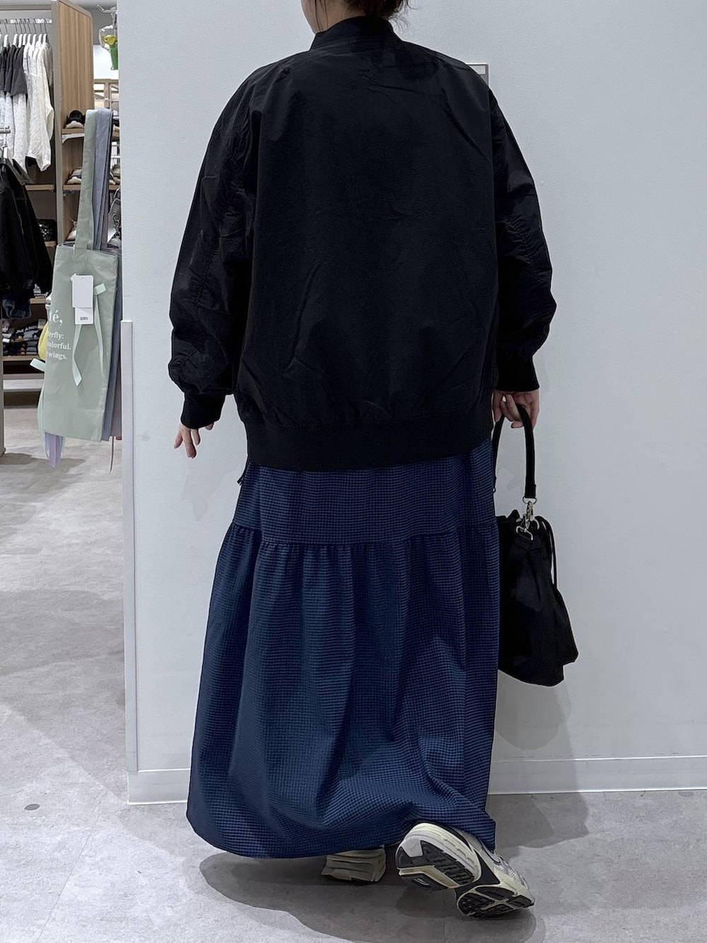 ブラック系のショルダーバッグ、ブラック系のブルゾン、ブルー系のワンピースを着用したレディースの春コーディネートの3枚目の写真