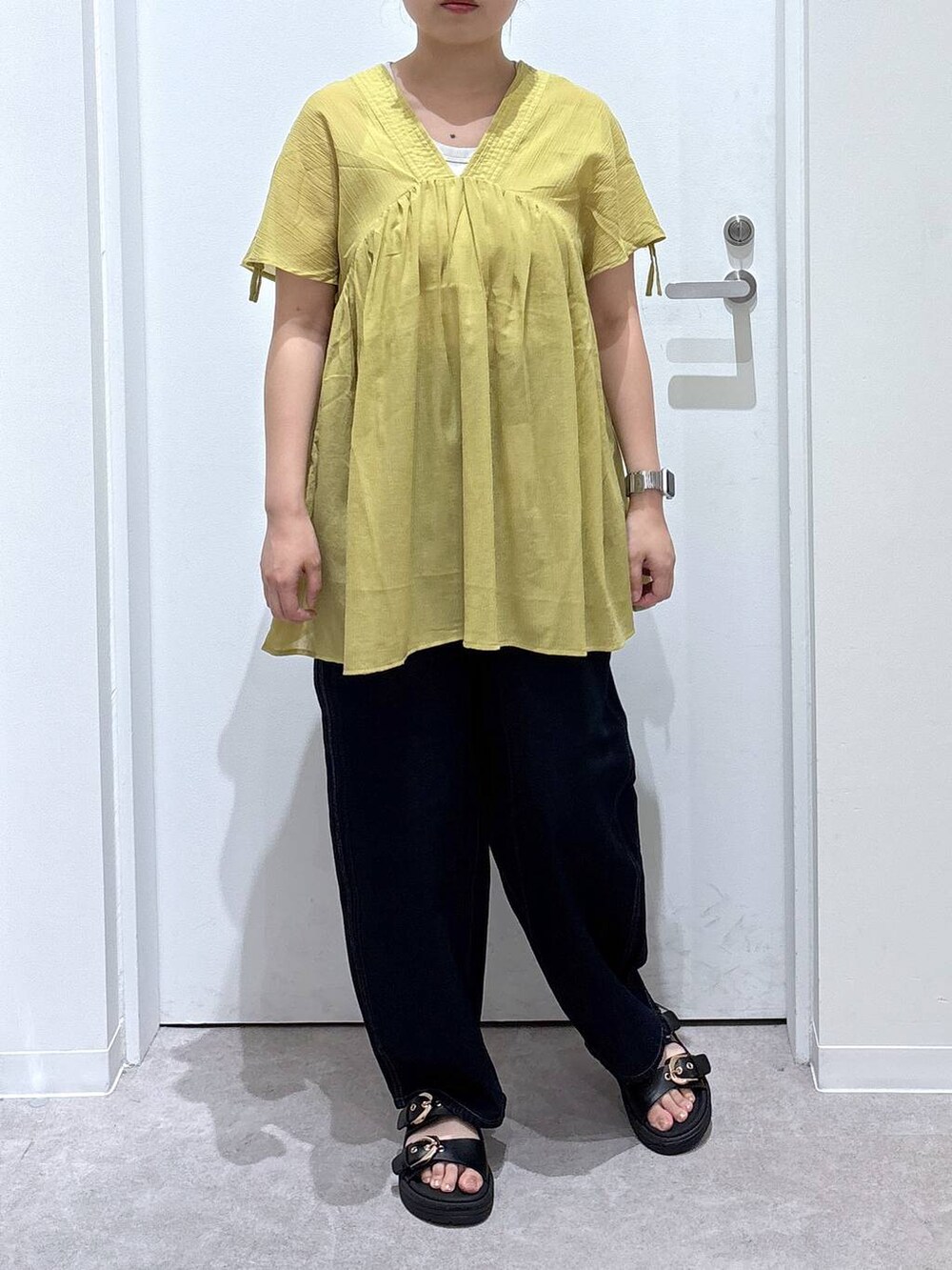 ブルー系のデニムパンツ、イエロー系のシャツ/ブラウス、ブラック系のサンダルを着用したレディースの夏コーディネートの5枚目の写真