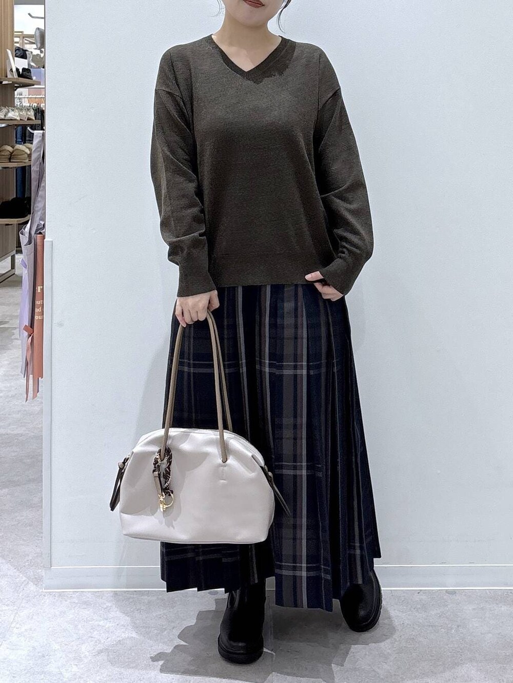 ホワイト系のボストンバッグ、ホワイト系のブルゾン、ブラック系のブーツを着用したレディースの冬コーディネートの4枚目の写真