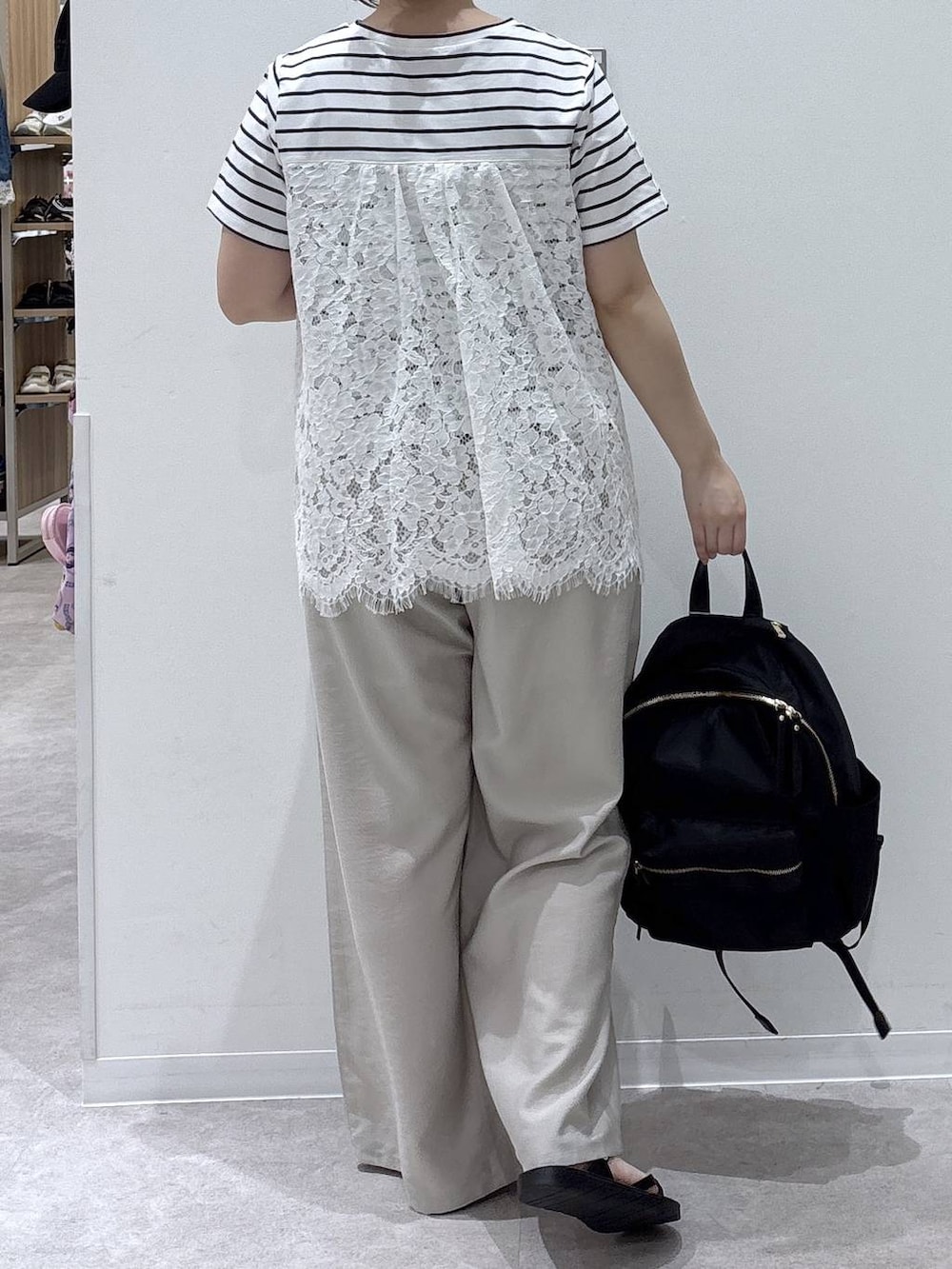 ブラック系のバックパック/リュック、ベージュ系のその他パンツ、ホワイト系のTシャツ/カットソーを着用したレディースの夏コーディネートの3枚目の写真