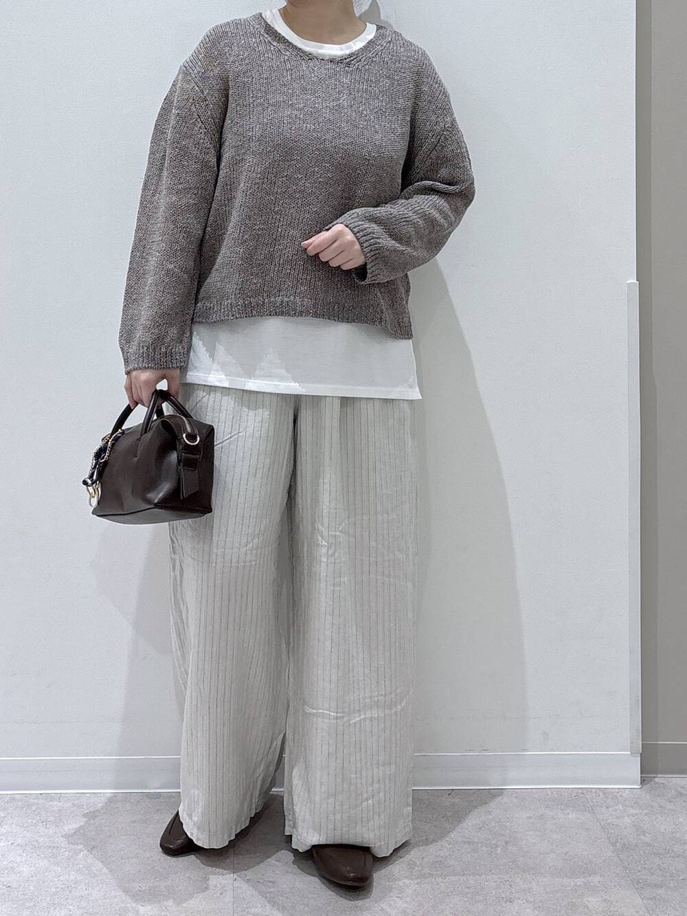 ブラウン系のボストンバッグ、ベージュ系のその他パンツ、ベージュ系のニット/セーターを着用したレディースの春コーディネートの5枚目の写真