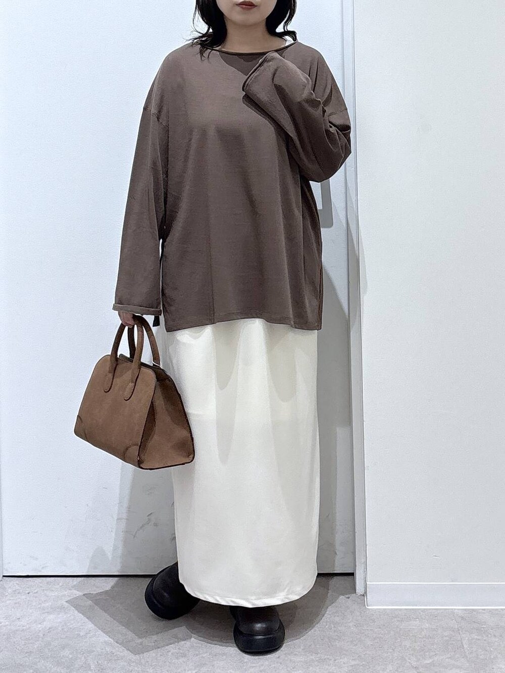 ベージュ系のショルダーバッグ、ベージュ系のスカート、ブラウン系のTシャツ/カットソーを着用したレディースの秋コーディネートの6枚目の写真