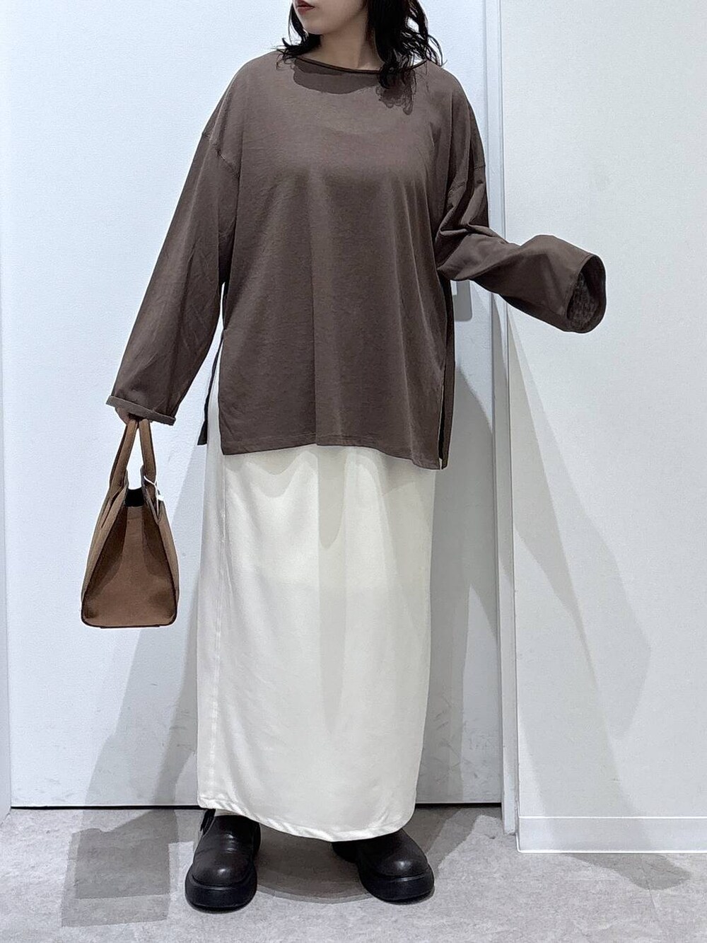 ベージュ系のショルダーバッグ、ベージュ系のスカート、ブラウン系のTシャツ/カットソーを着用したレディースの秋コーディネートの5枚目の写真