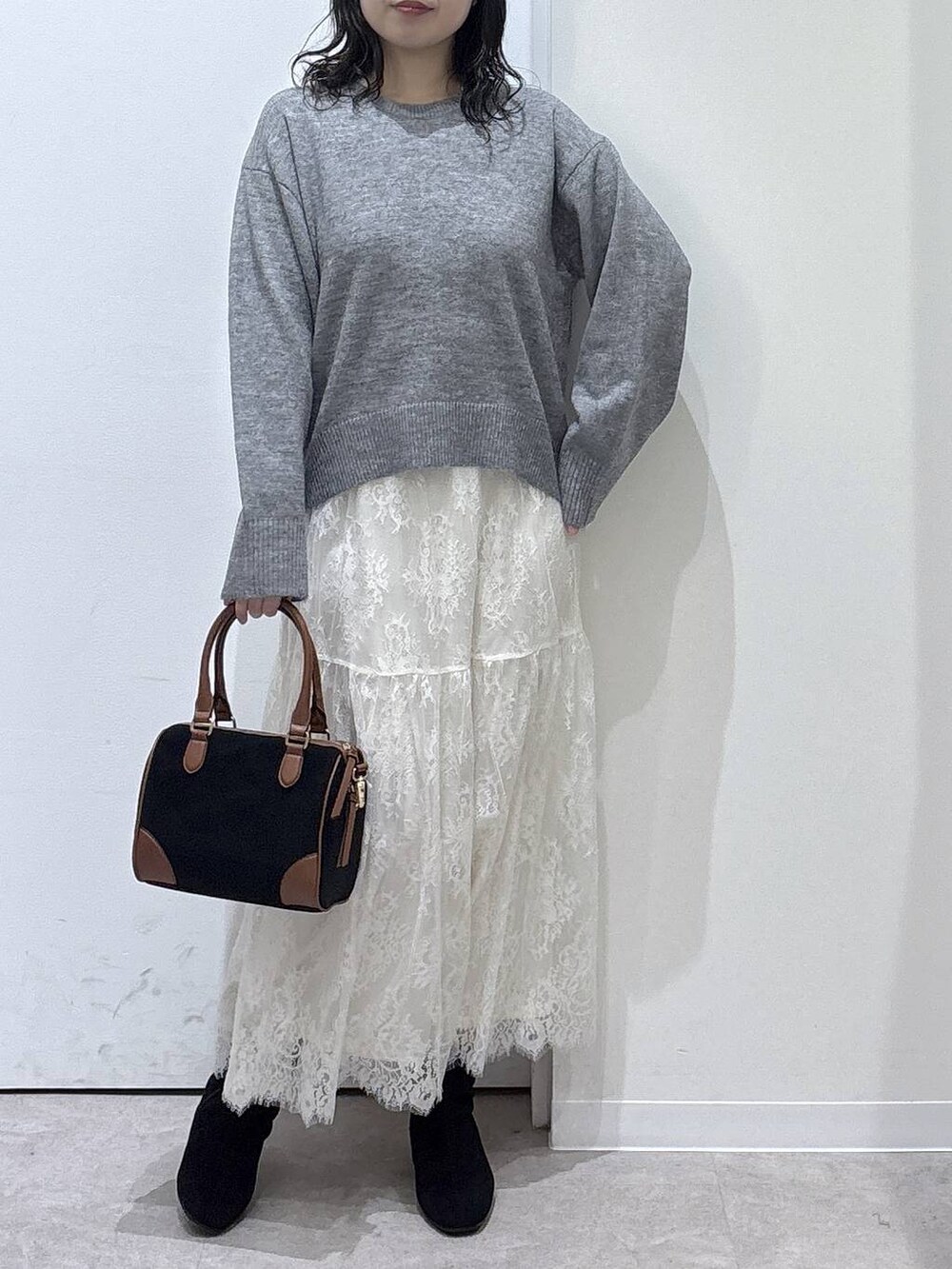 ベージュ系のノーカラーコート、グレー系のワンピース、ブラック系のボストンバッグを着用したレディースの秋コーディネートの4枚目の写真