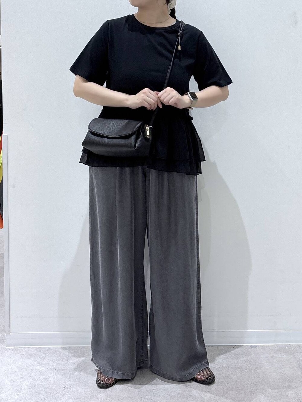 ブラック系のショルダーバッグ、ブラック系のデニムパンツ、ブラック系のサンダルを着用したレディースの夏コーディネートの4枚目の写真