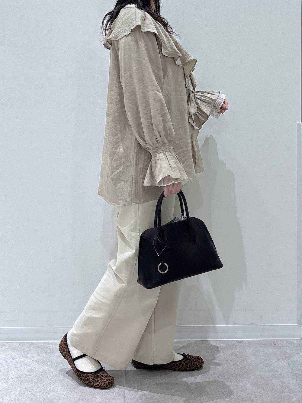 ブラック系のショルダーバッグ、ホワイト系のその他パンツ、ベージュ系のシャツ/ブラウスを着用したレディースの春コーディネートの2枚目の写真