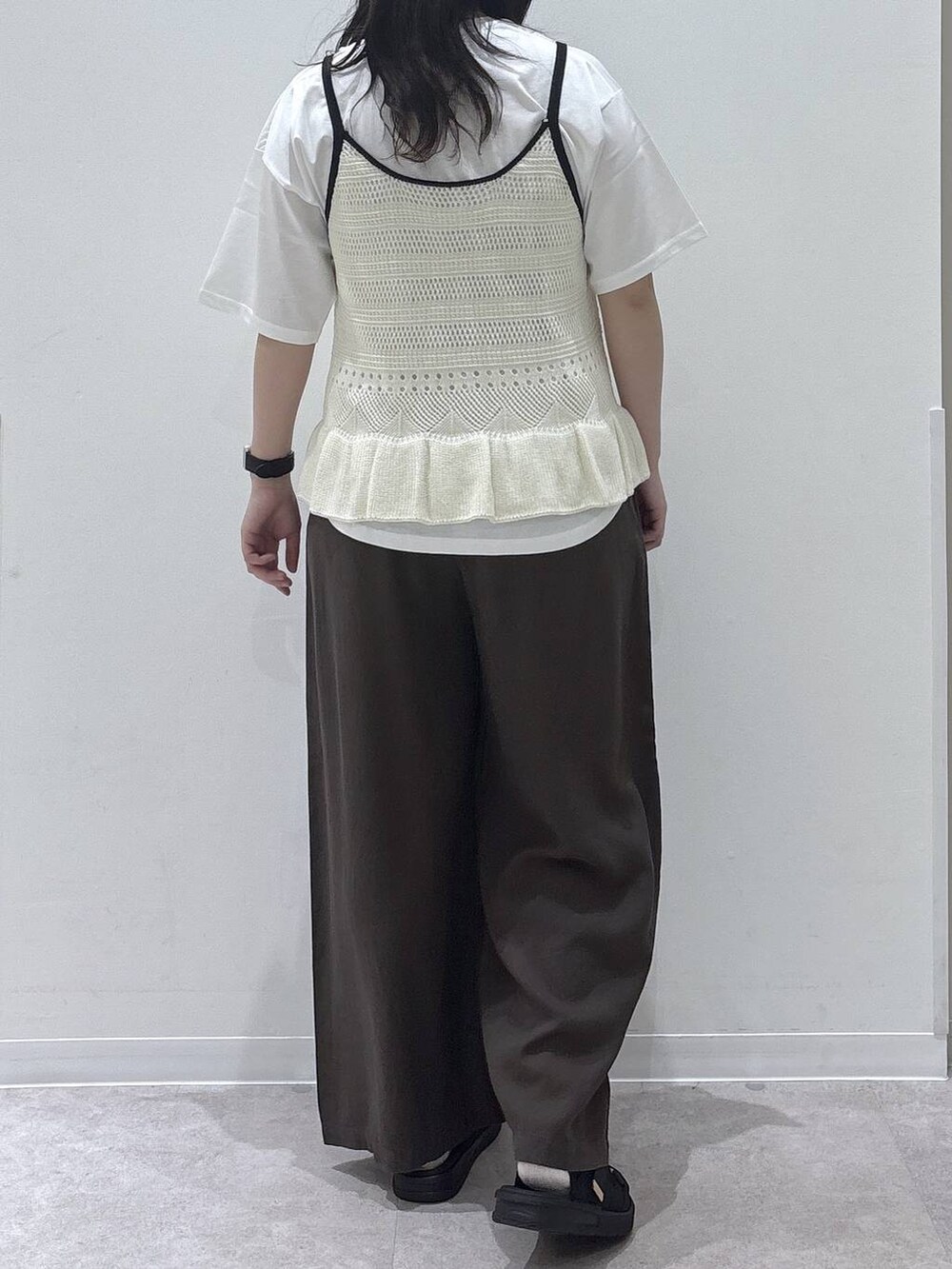 ブラウン系のその他パンツ、ホワイト系のTシャツ/カットソー、ブラック系のサンダルを着用したレディースの春コーディネートの3枚目の写真