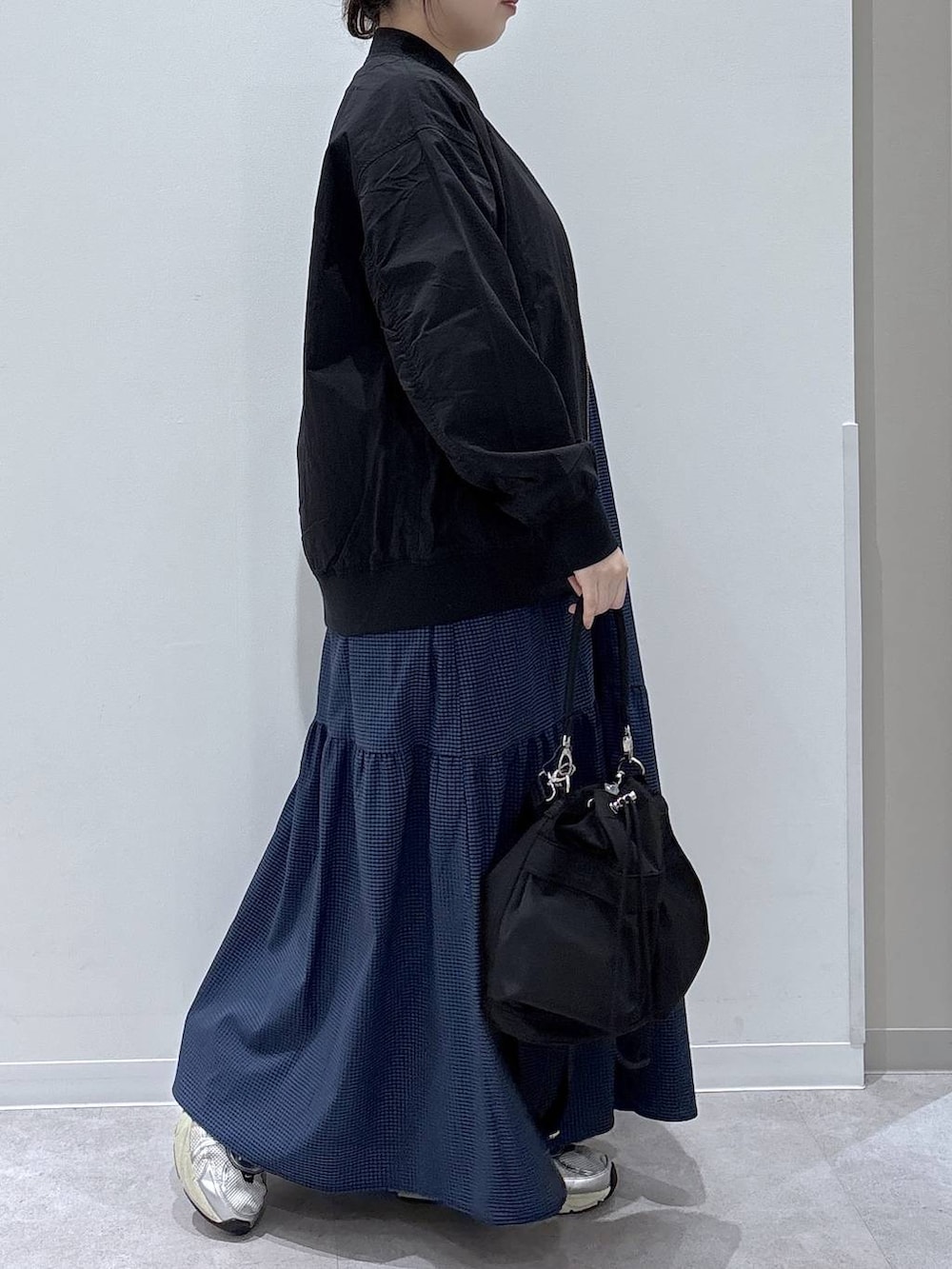 ブラック系のショルダーバッグ、ブラック系のブルゾン、ブルー系のワンピースを着用したレディースの春コーディネートの2枚目の写真