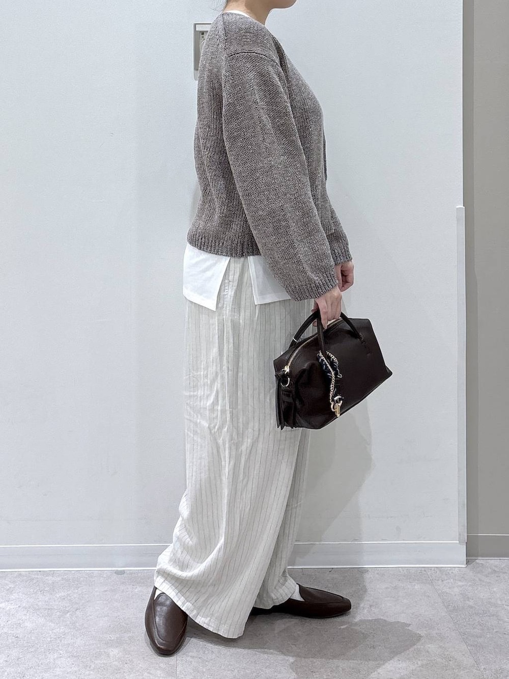 ブラウン系のボストンバッグ、ベージュ系のその他パンツ、ベージュ系のニット/セーターを着用したレディースの春コーディネートの2枚目の写真